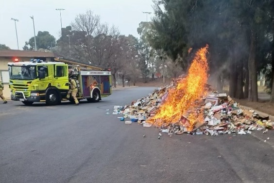 A fire engine arrives to put out a mound of rubbish that caught fire.