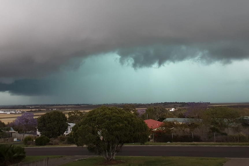 A savage looking storm surges inexorably towards a small town.