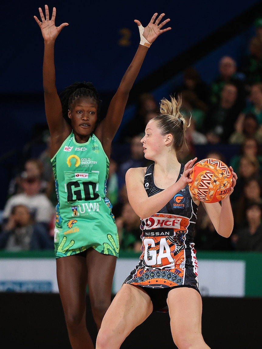 Two women playing a game of netball