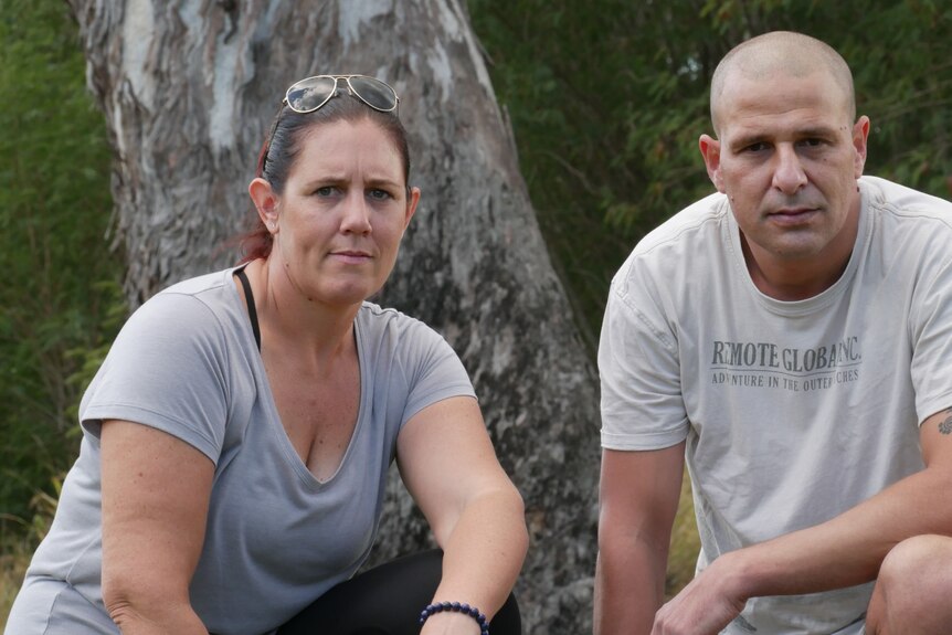 Anna Schollum and Daniel Thompson kneel underneath a gum tree in a park at Ipswich, west of Brisbane.