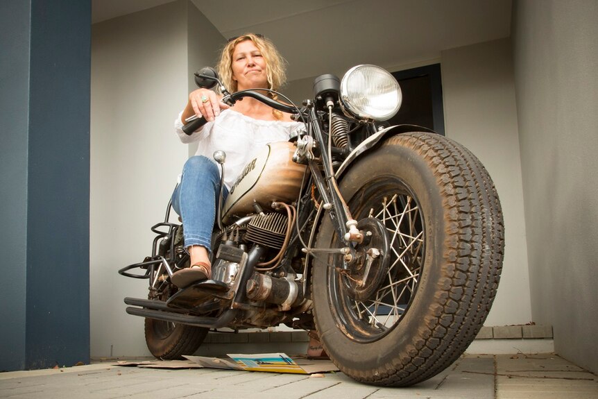 Counsellor Julie Jasper is sitting on her 1942 Indian 741 Military Scout motorbike
