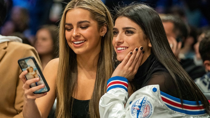 Addison Rae and Dixie D'Amelio smiling in a crowd 