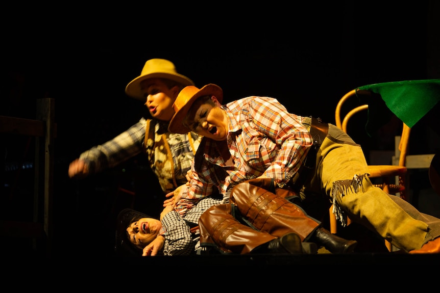 a mock cowboy bar room fight on stage