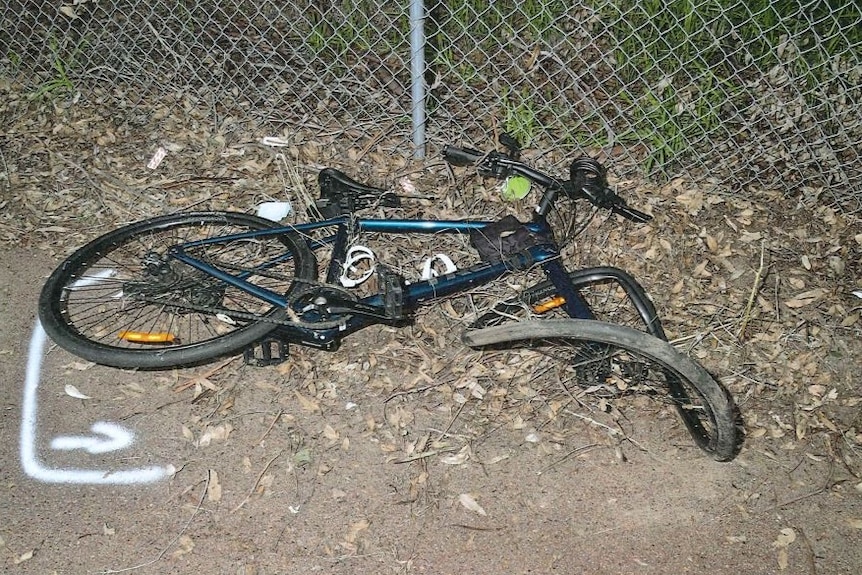 A pushbike on the ground with a badly damaged front tyre. 