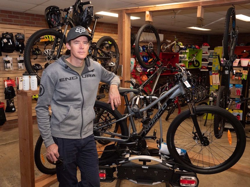 Man with bicycles inside retail store.