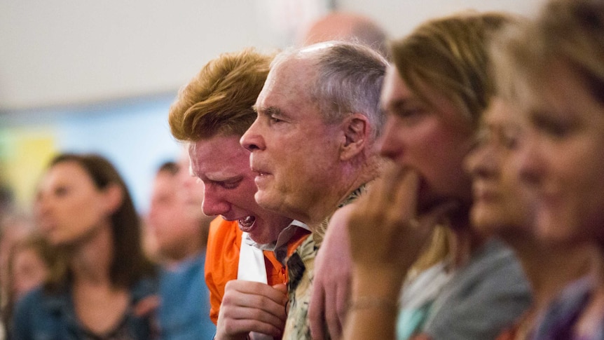 A group cries in the church after the Texas school shooting