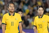 Matildas players Emily van Egmond, Mary Fowler and Sam Kerr stand on a football field waiting for a corner.