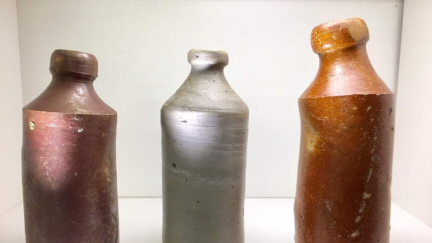 Three clay bottles on a white table