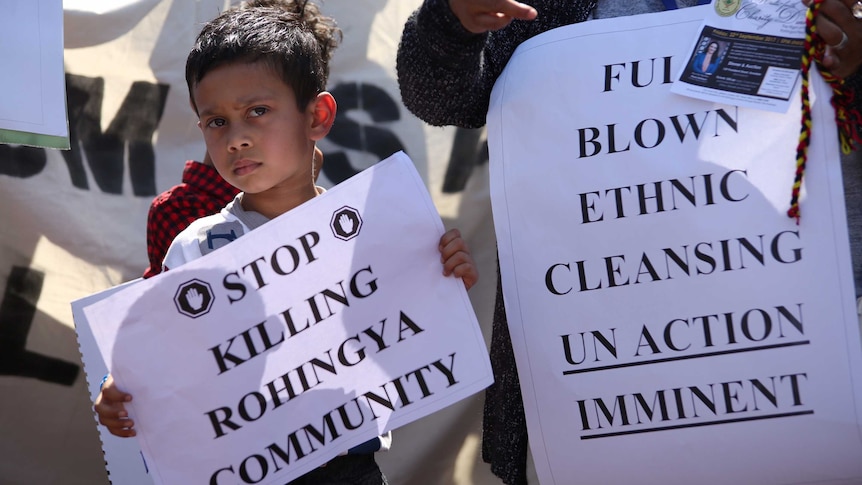 Young protesters hold banners.