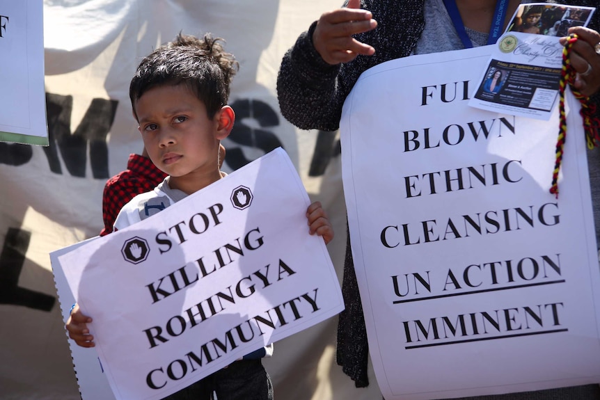 Young protesters hold banners.