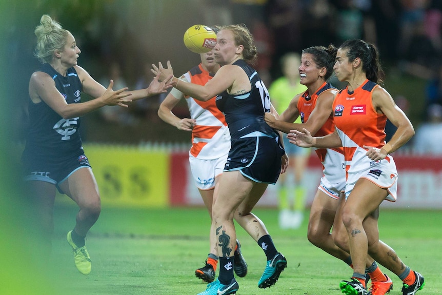 Carlton and GWS players come together in a storm