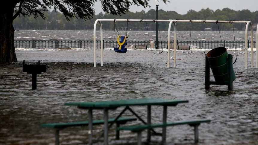 A picnic table and playground equipment just above flood waters.