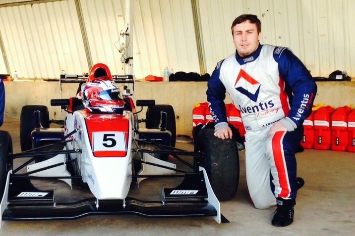 Adam Cranston pictured with a small navy and red race car in 2016.