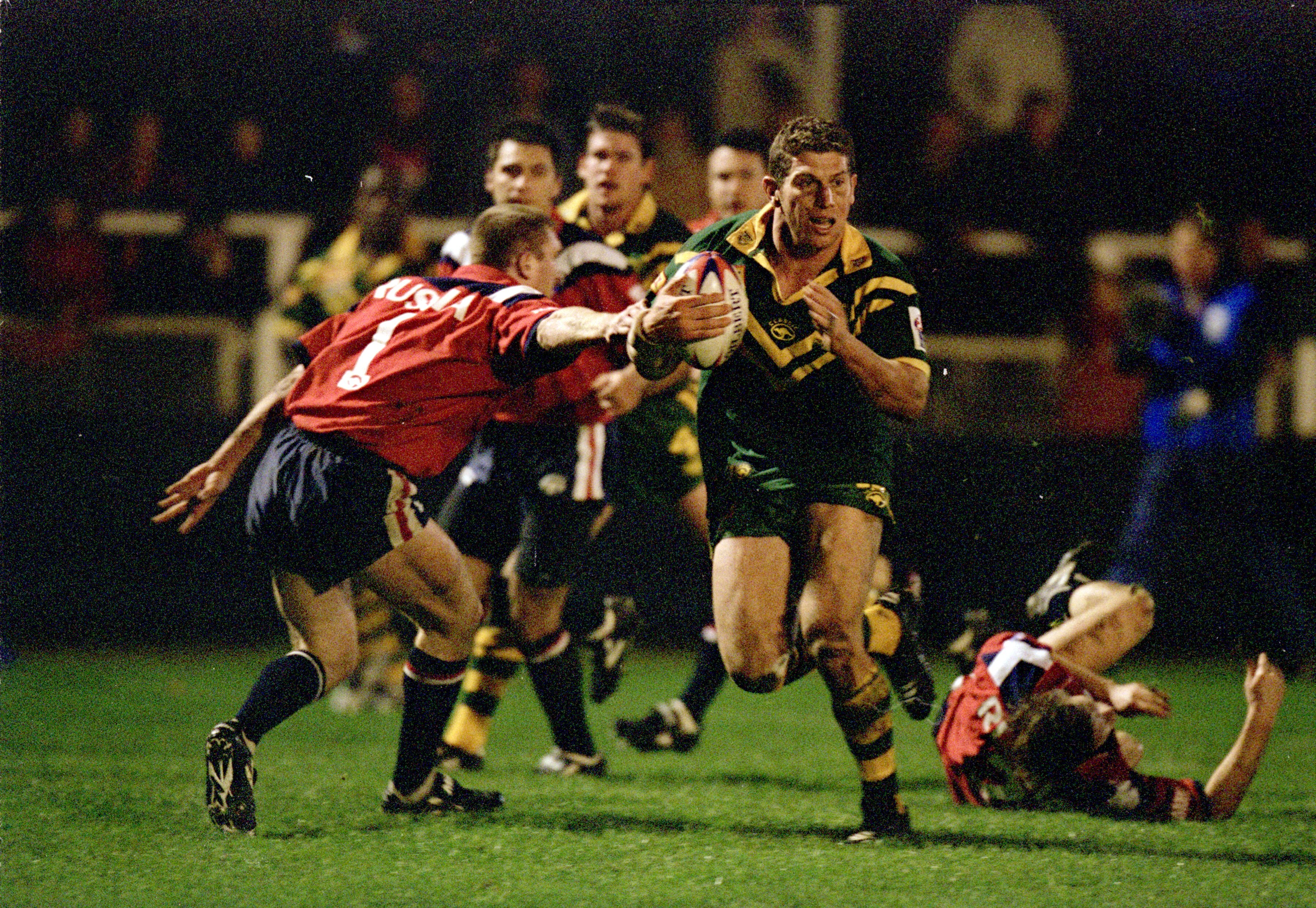 A man runs the ball during a rugby league match
