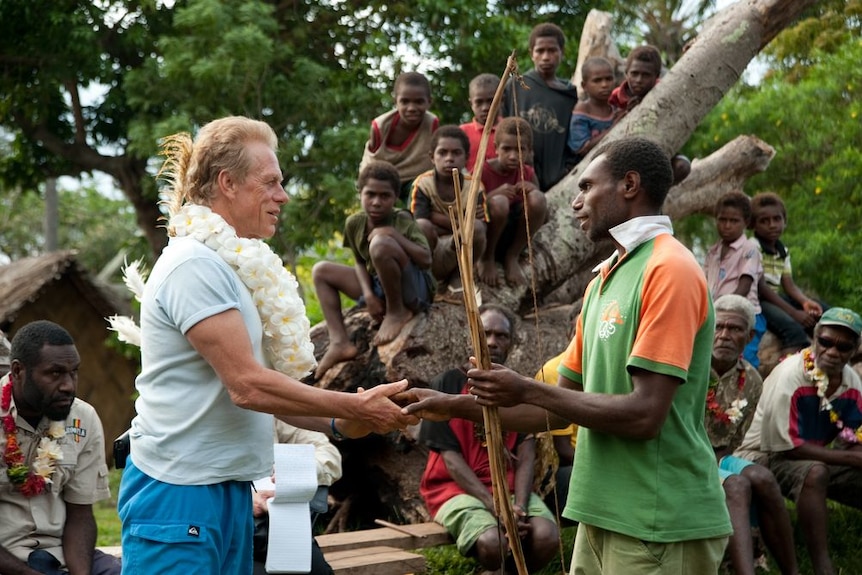 A chief from the volcanic island of Tanna in Vanuatu presents Alby Mangels with a gift.