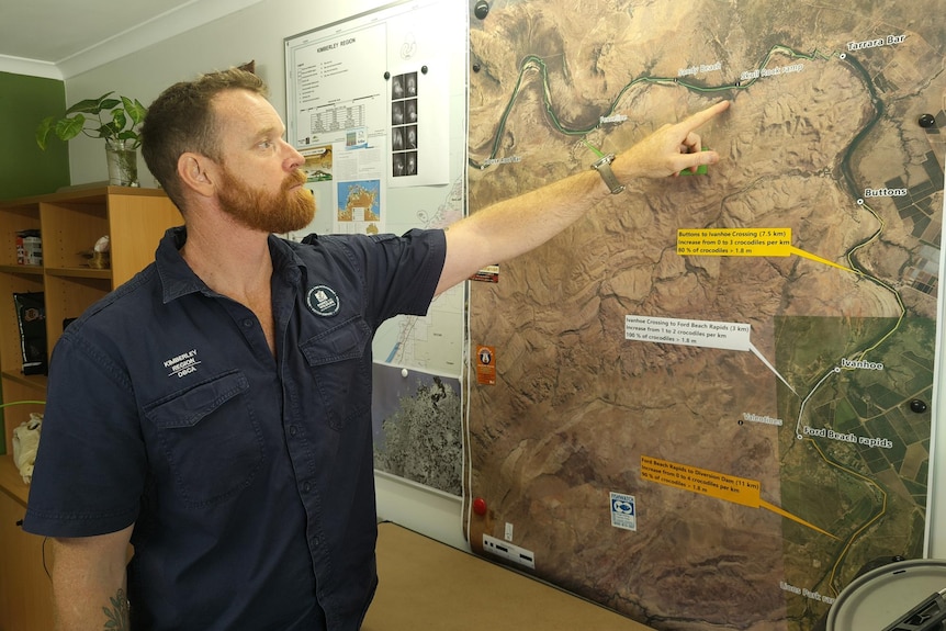 a man points to a detailed photographic map of the river showing common spots for people