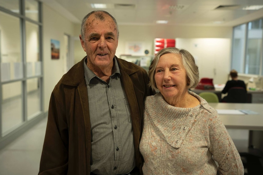 Geoff and Ruth Byrne stand with their arms around each other at the WA Herbarium.