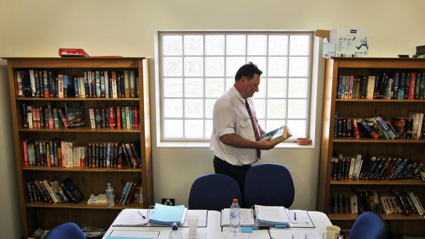 Education Coordinator Peter Fox returns books to the Mount Gambier Prison library bookshelves.