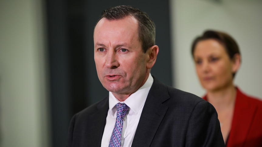 A head and shoulders shot of WA Premier Mark McGowan speaking at a media conference indoors wearing a suit and tie.