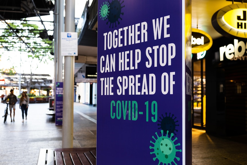 A public sign reads 'Together we can help stop the spread of COVID-19'.