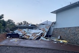 Part of a house collapsed onto two cars.