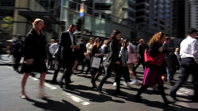 Office workers cross the street in Sydney