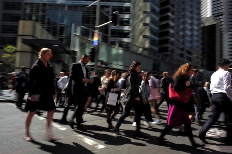 Office workers cross the street in Sydney