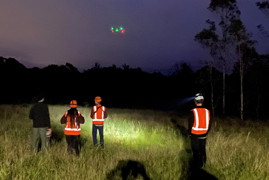 a group of people out in the wilderness operating a drone