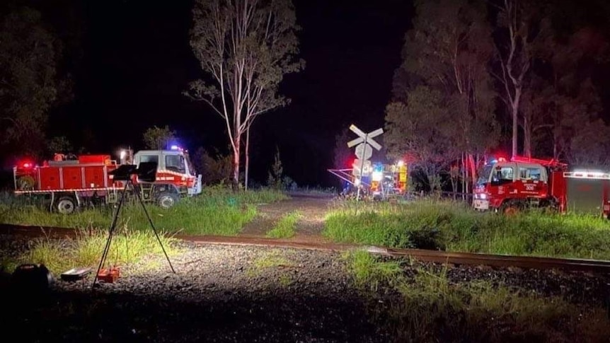 Fire trucks attend a train that hit a fallen tree near Grafton, NSW