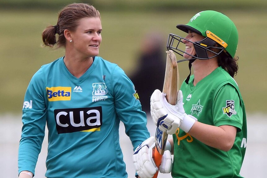 Jess Jonassen and Katey Martin smile at each other wearing cricket kit
