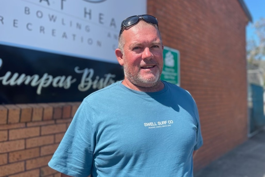 Hat Head Bowling Club board member Graham Eager stands in front of a brick building