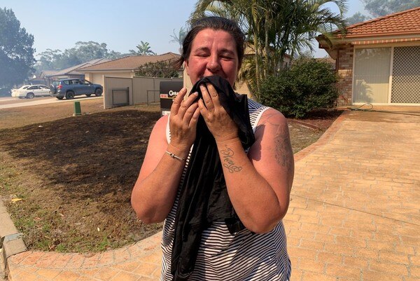Jodie Sutor covers her mouth with a towel in Wardell, northern NSW.