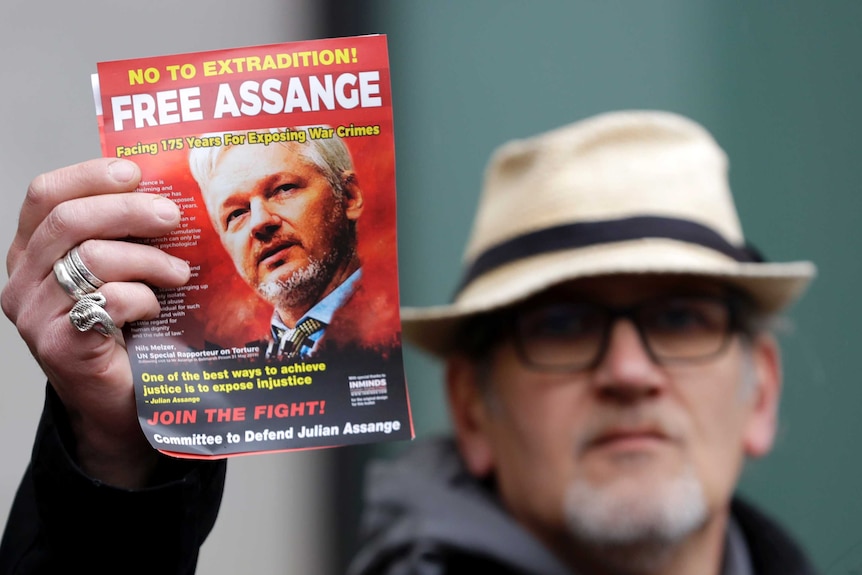 A pro-Assange demonstrator holds a leaflet outside Westminster Magistrates Court in London.