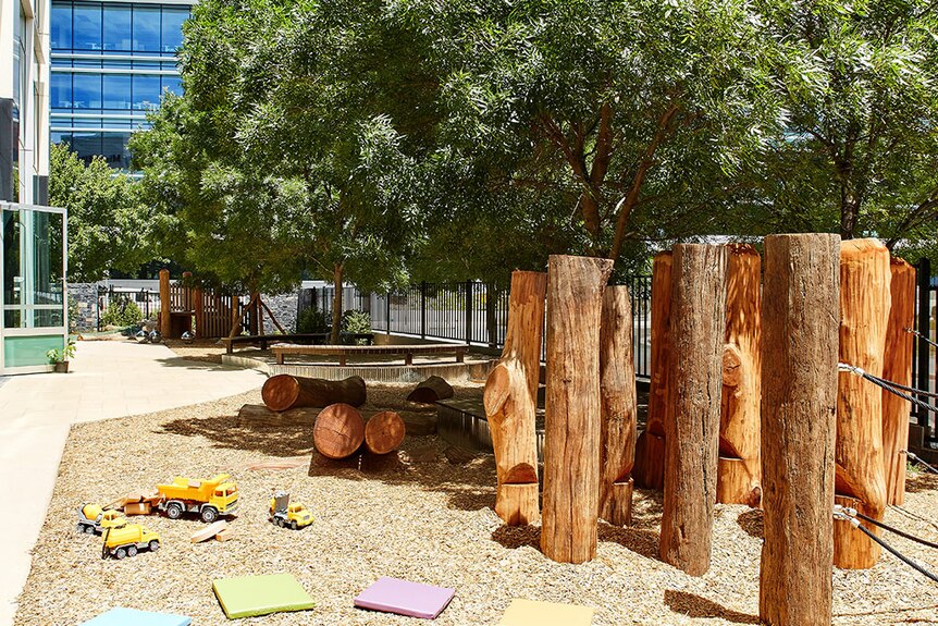 outside area of a childcare centre with logs poking up