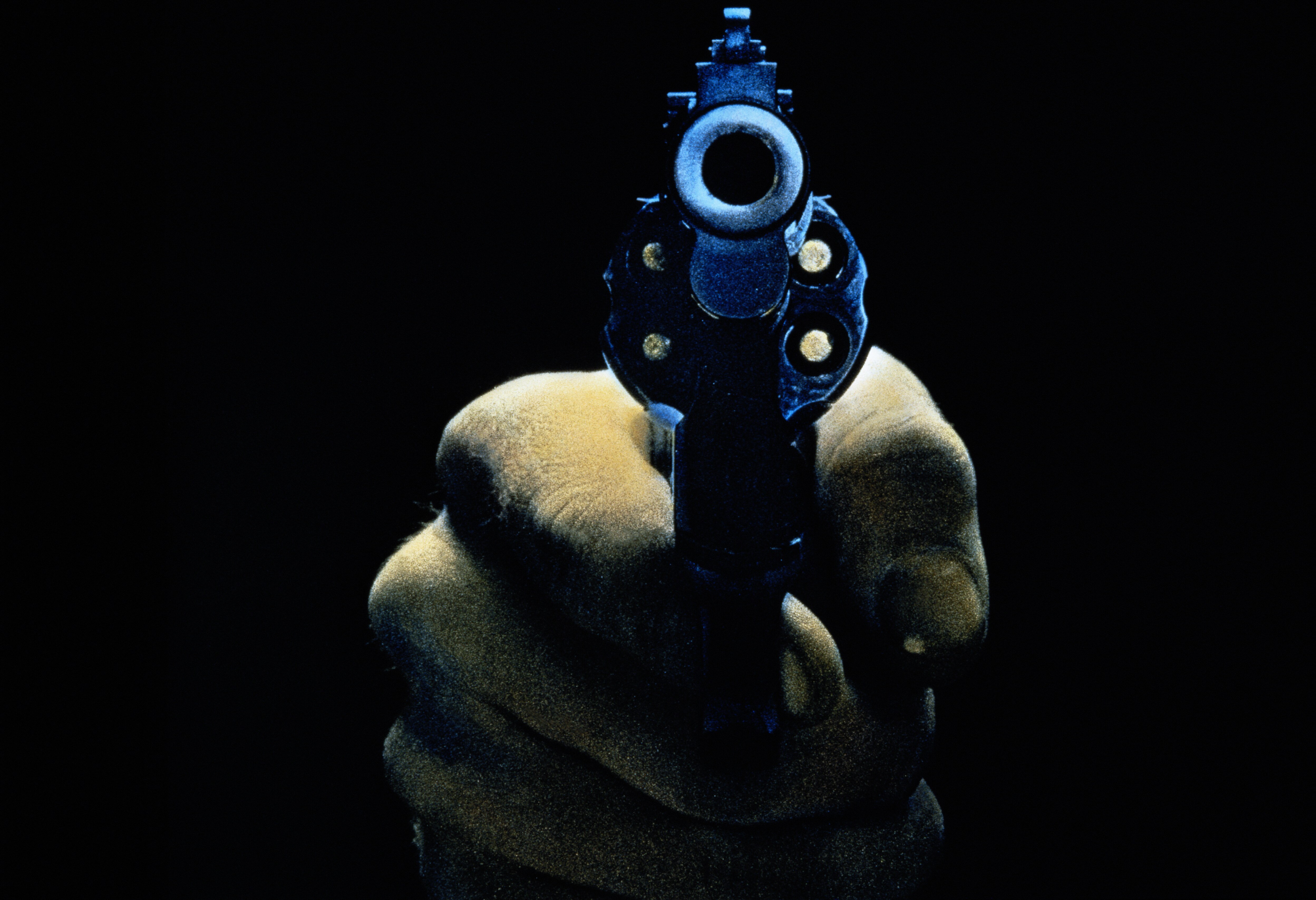 Close up image of a gun being held facing towards the camera.