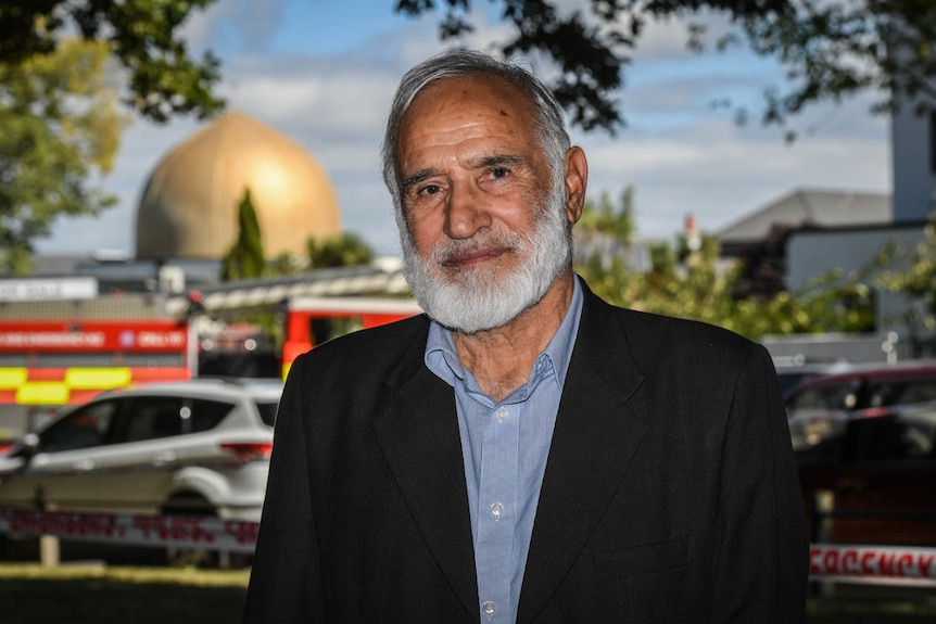 A man looks toward the camera as a golden dome can be seen in the background.