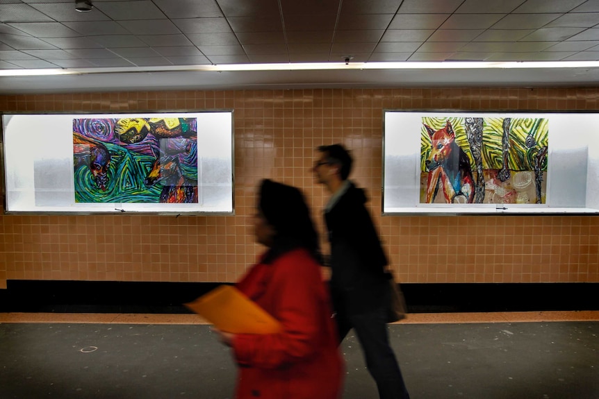 People walking past the Dirty Dingoes exhibition.