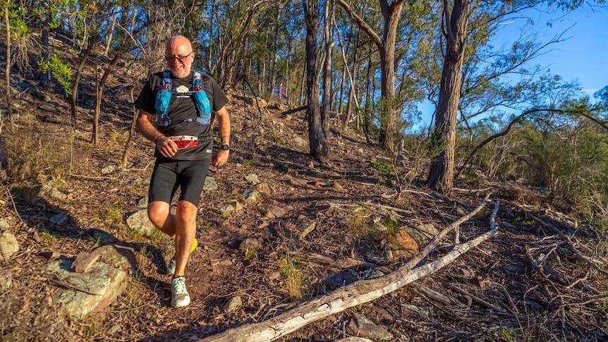 An older man on a trail run in the bush.