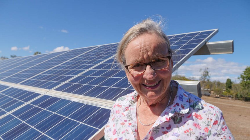 Sylvia Wilson stands in front of her home solar panels