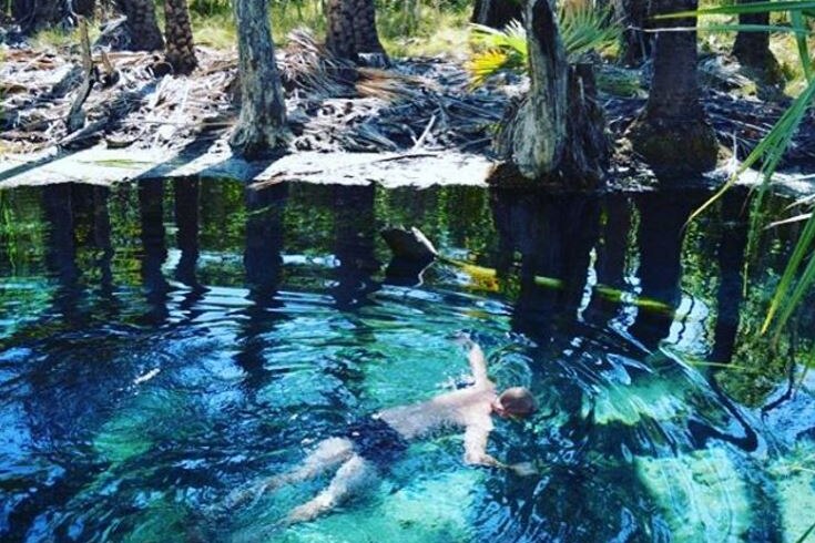 A person floating in a warm spring near Mataranka