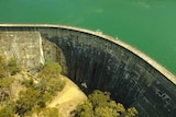 A large dam with blue-green water behind its wall.