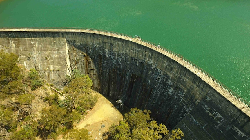 A large dam with blue-green water behind its wall.