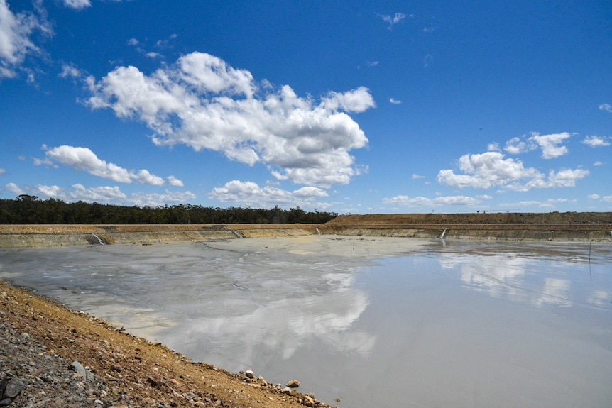 A large dam with sediment to one side