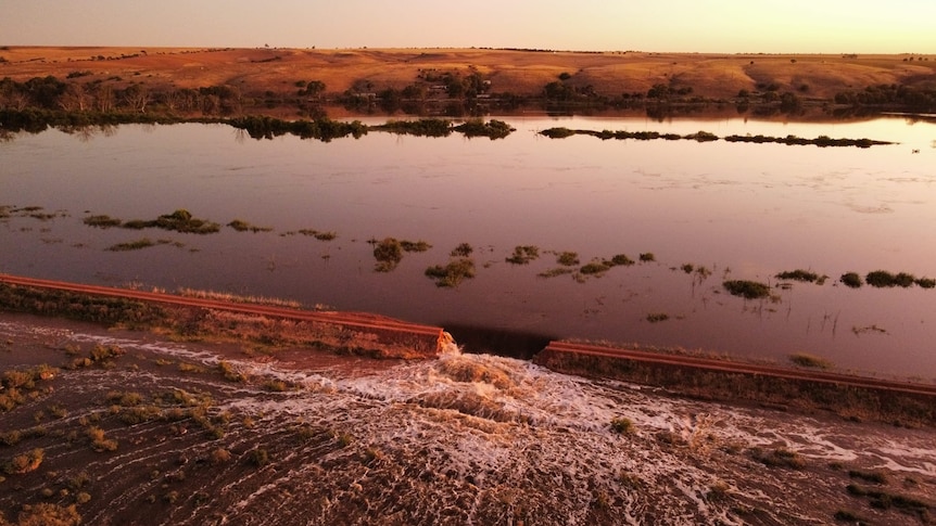 levy breach in foreground showing gushing water from River Murray