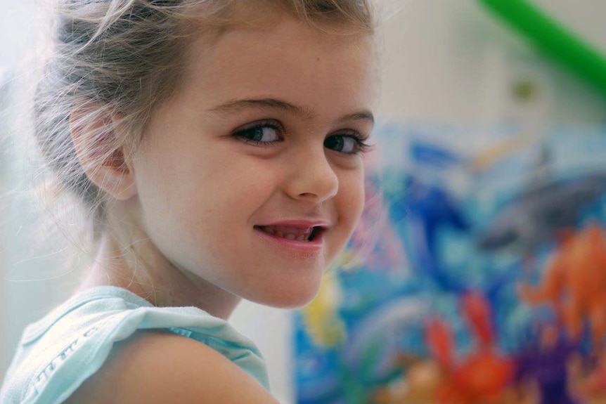 Pre-primary student Savannah smiles while sitting in the hospital.