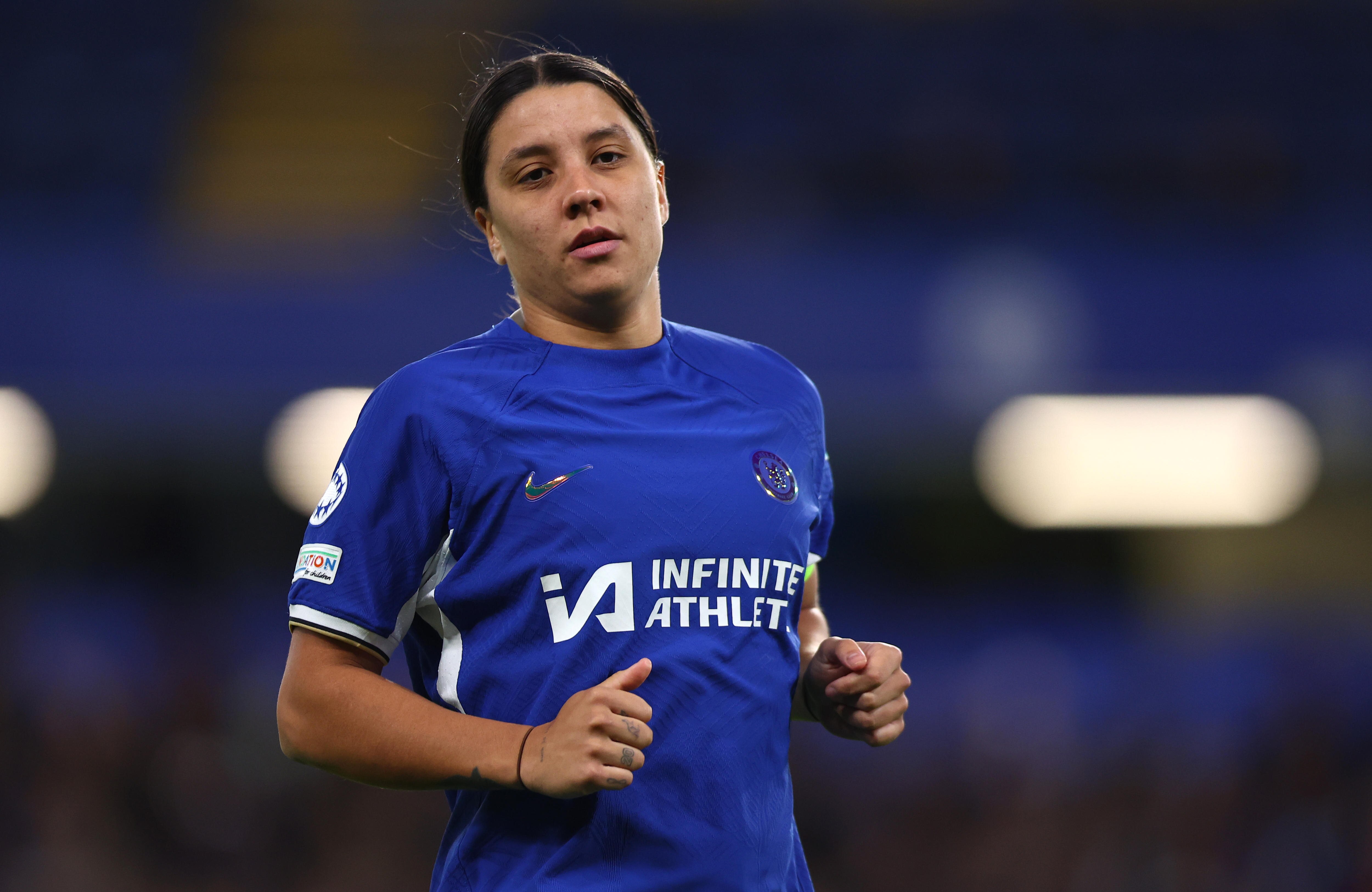 Chelsea's Sam Kerr looks serious as she stands on a pitch during a game. 