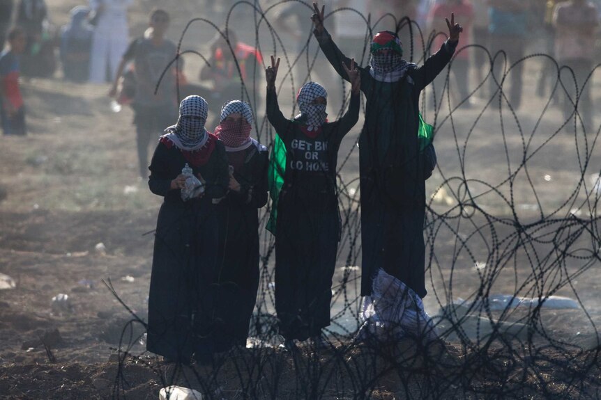 Palestinian women are seen flashing victory signs.