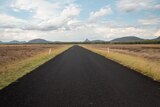 A straight road with mountains in the distance, near Capella, Queensland, November 2021.