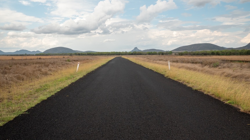 A straight road with mountains in the distance, near Capella, Queensland, November 2021.