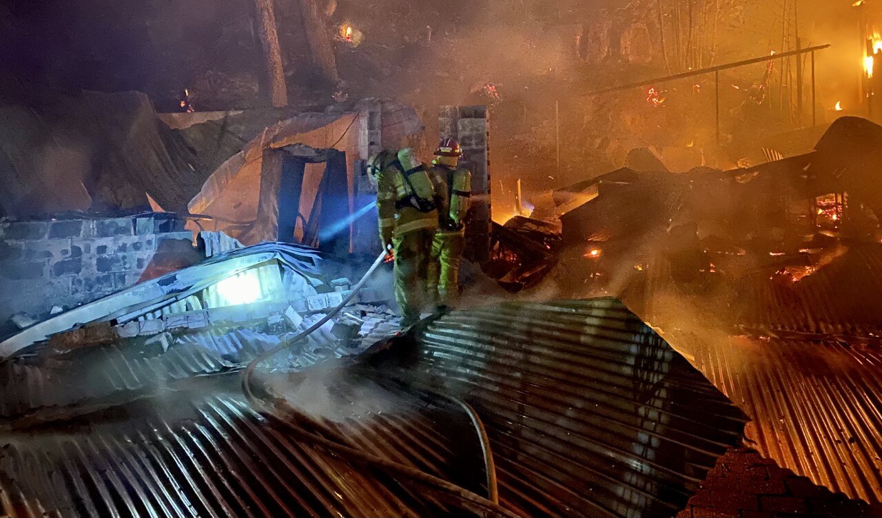 The smoking ruins of a restaurant, with the roof fallen into the room below
